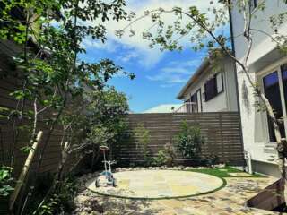 空の青、樹木の緑、庭の石。幾何学模様と自然の模様が重なって見える景色。