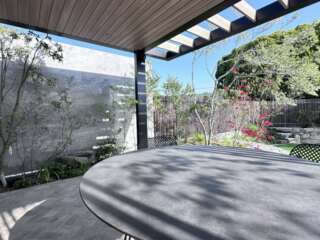 テラスのくつろぎ空間に差し込む外部の光。植物がかざす陰影を景色として眺める場所。